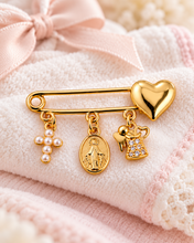 Pearl cross and heart baby blessing pin with Virgin Mary medal and angel charm on a soft pink blanket