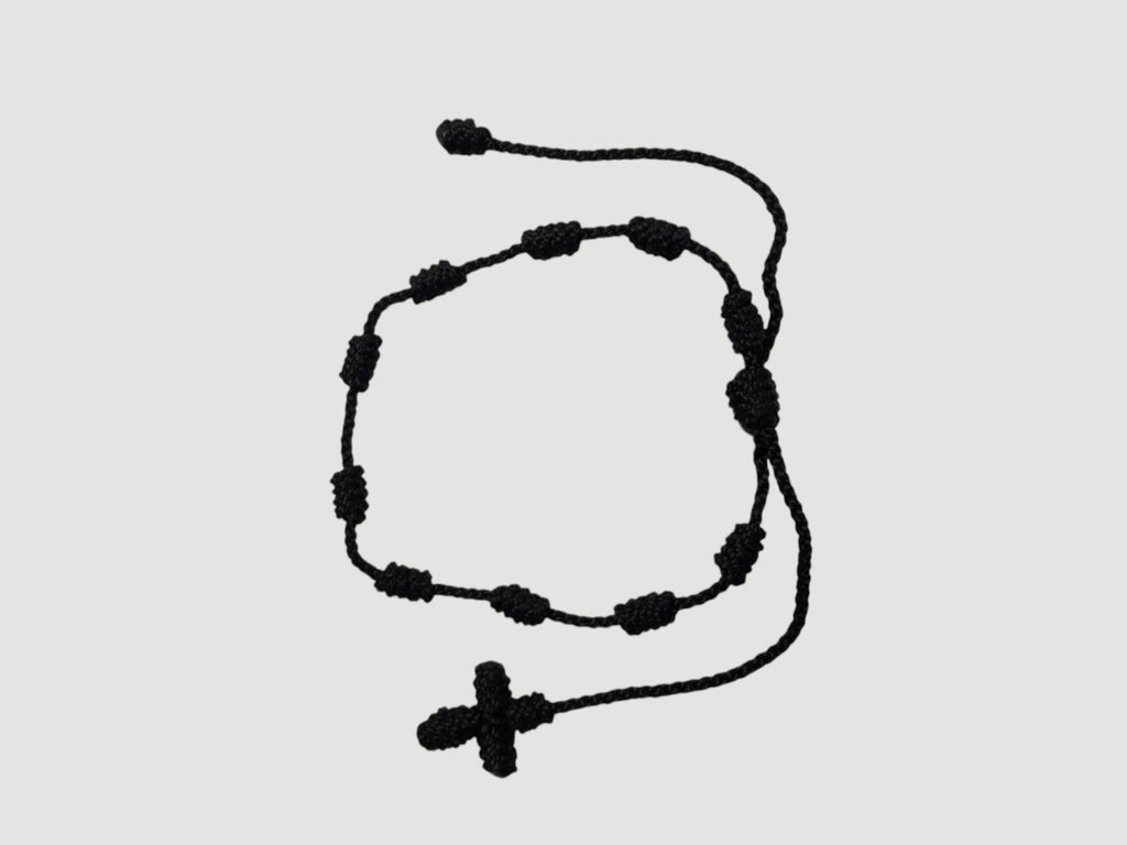 Black adjustable knotted decade cord bracelet with woven cross