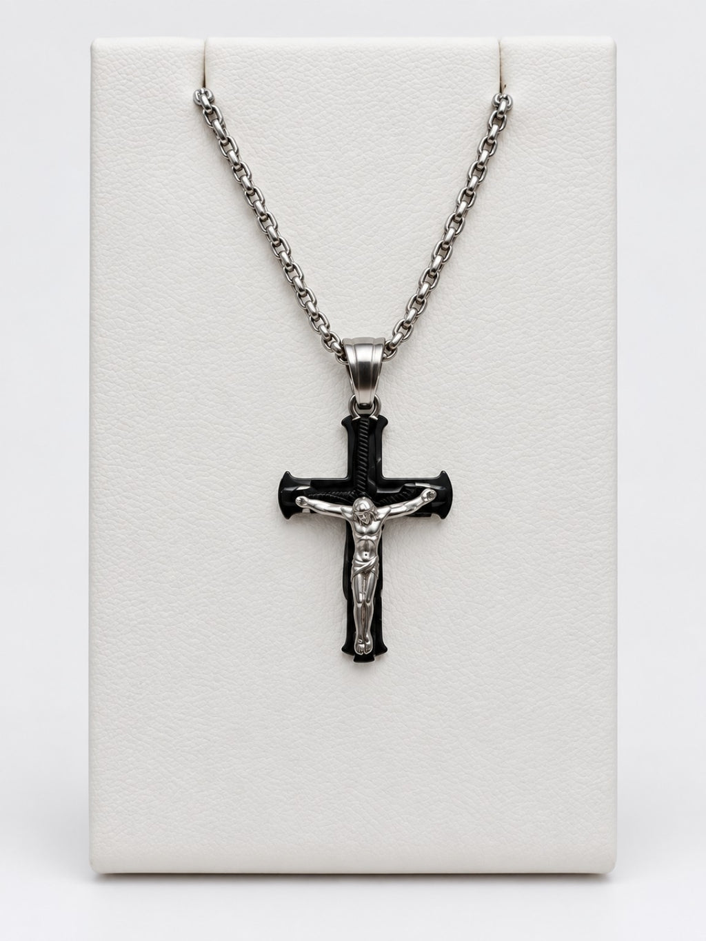 A black flared crucifix with a silver-tone figure of Jesus, silver-tone bail and silver-tone chain.
