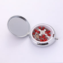 Holy Spirit red crystal rosary inside open metal keepsake box with Saint Benedict crucifix