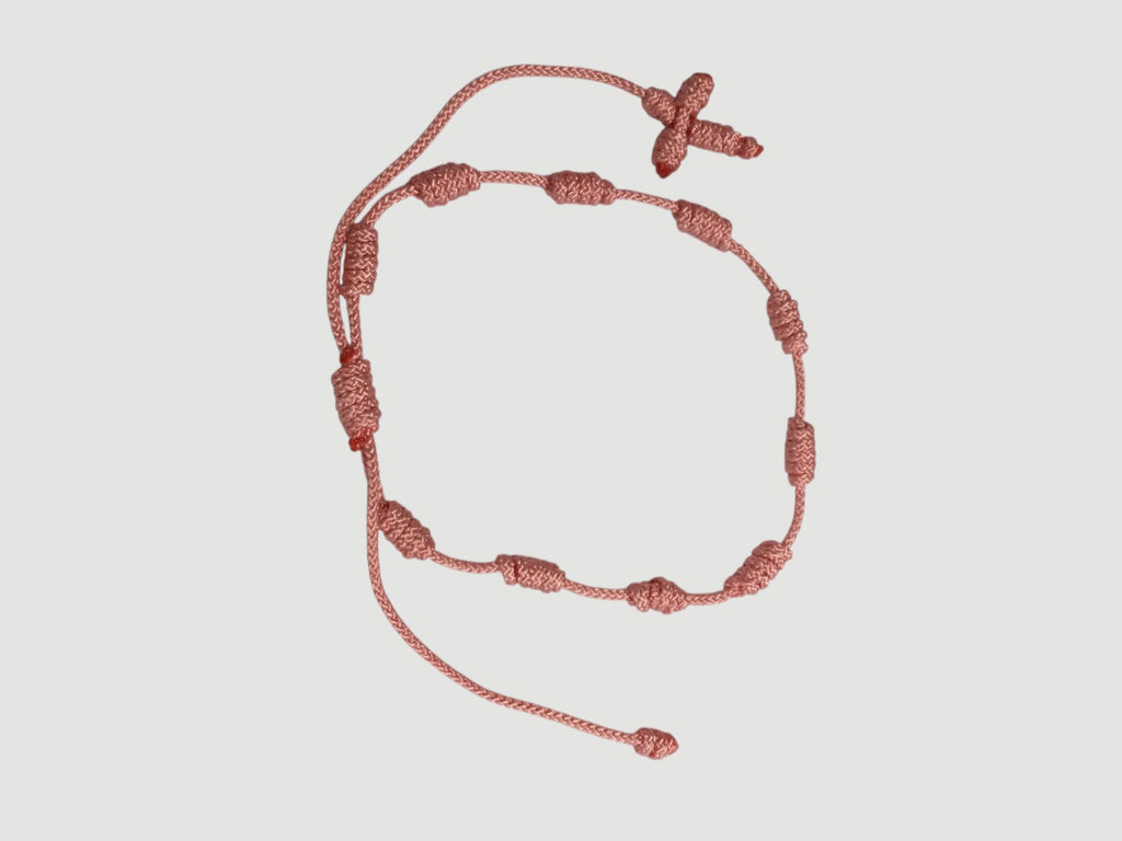 Pink adjustable knotted decade cord bracelet with woven cross