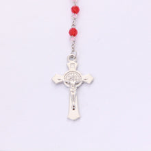 Front of Saint Benedict crucifix on red crystal devotional rosary