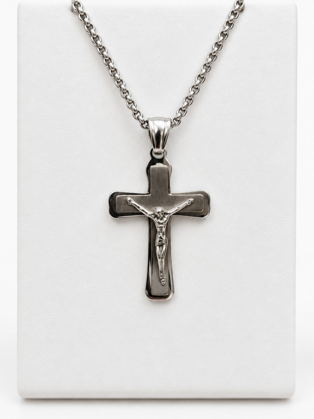 A silver-tone crucifix with a brushed-look center, polished border and a raised figure of Jesus.