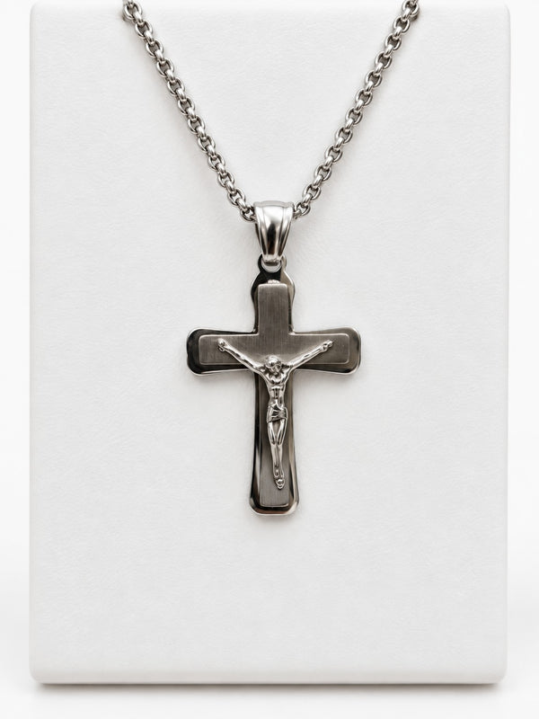 A silver-tone crucifix with a brushed-look center, polished border and a raised figure of Jesus.