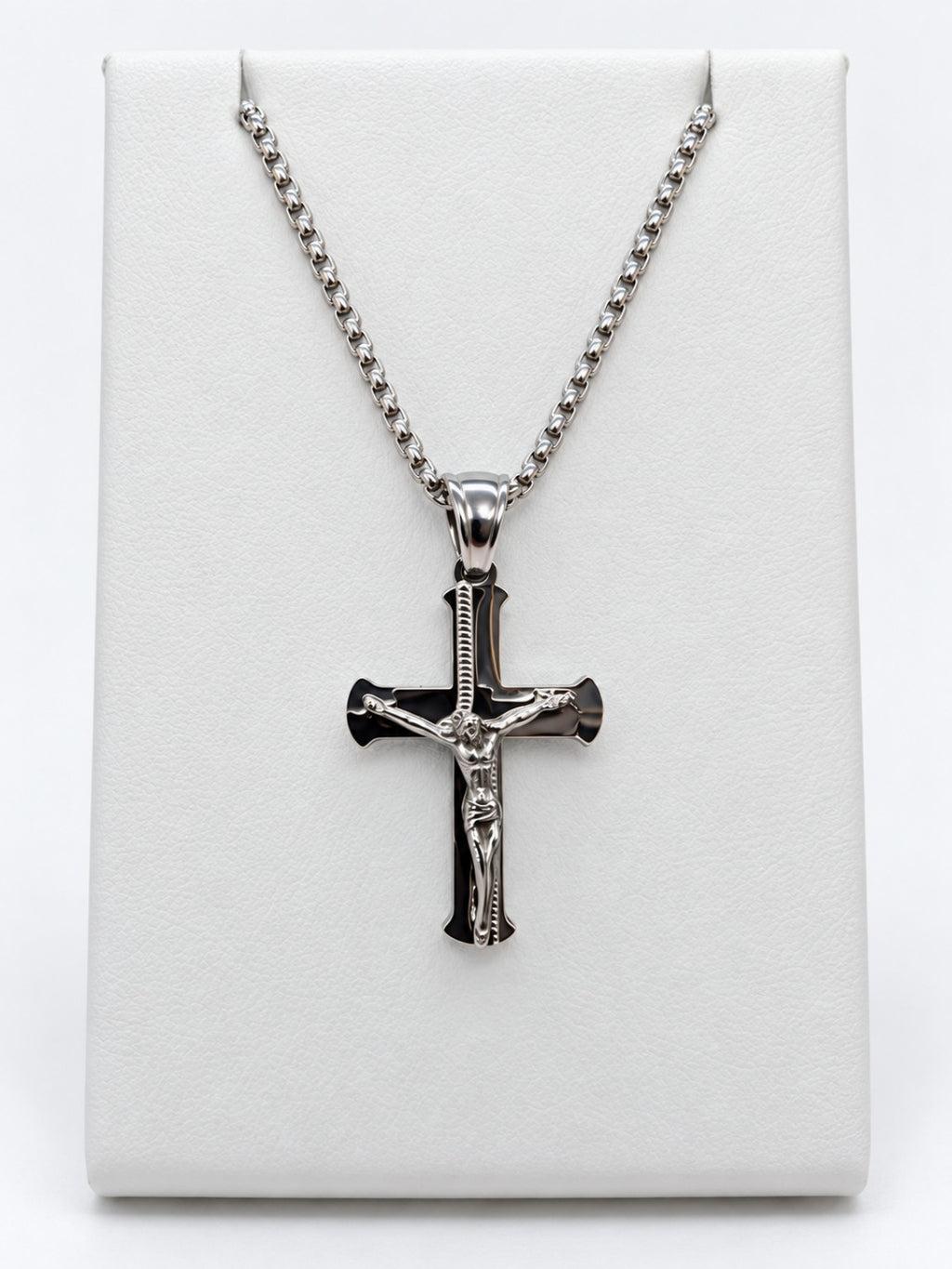 A polished silver-tone crucifix with flared cross ends and a raised figure of Jesus.